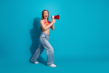 Energetic young woman with a megaphone, expressing excitement against a vibrant blue background in...