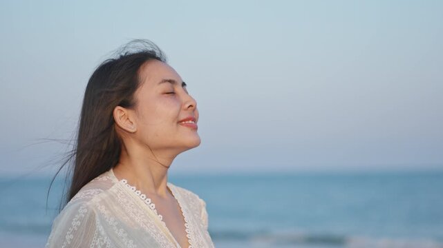 Happy Asian Woman Breathing and Closed Eyes on the Beach and Sea Horizon