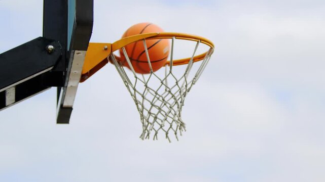 basketball hoop and net. Basketball hoop in basketball court. basketball going through a hoop during a game in an outdoor and a blue sky.