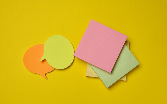 Multicolor sticky notes of various shapes and speech bubbles on a bright yellow background.