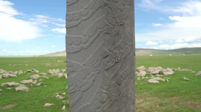 Asian deer stone monument bears ritual symbols on an ancient burial stele in open steppe.