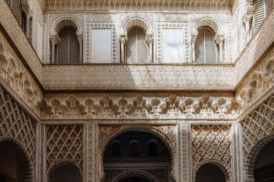 Detailed Mudejar plasterwork and arched galleries inside the Real Alcazar of Seville
