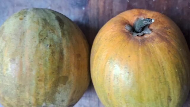 Close-up shot of fresh ripe canistel fruits (Pouteria campechiana) resting on a wooden table