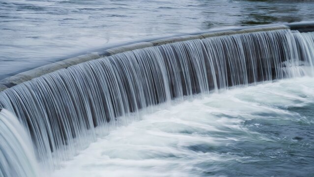 Curved weir waterfall with cascading water over dam wall waterfall cascading environment overflow landscape
