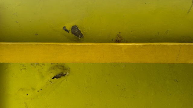 Underneath View of Yellow Concrete Slab with Peeling Paint and Cracked Structural Beam