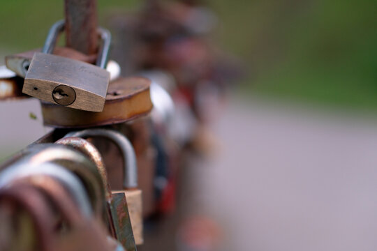 A collection of love locks attached to the metal railing of a bridge in Latvia. 