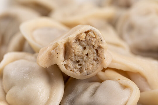 Boiled chicken meat dumplings cut in half showing minced poultry filling inside close up
