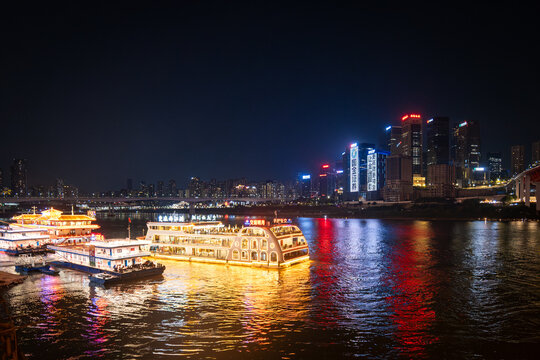 Chongqing, China - July 19, 2026: Chongqing city nighttime view of illuminated skyline and tourist boat for cruise on the river in Chongqing, China.