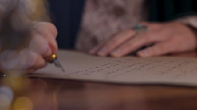 An antique young woman in a resurgent dress, sitting at the table and writing a letter with a vintage pen on an old paper sheet of parchment. The girl is writing a letter in handwritten script. 
