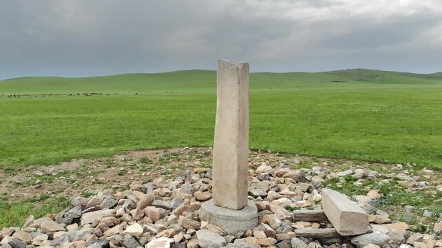 Stone kurgan and sacred stele stand on Mongolia steppe as ancient burial monument.