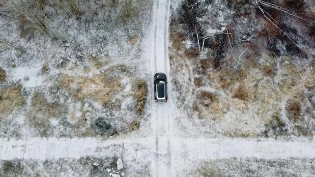 A car driving along a snowy forest road.