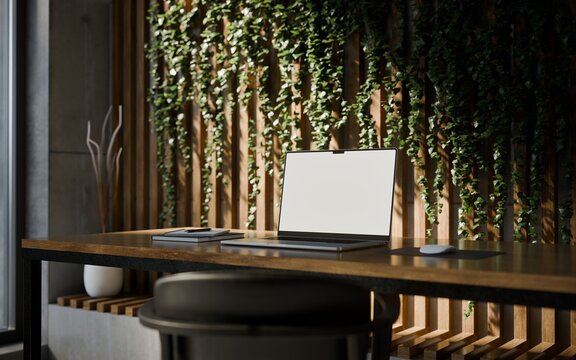 Laptop with Frame Less Blank Screen in Modern Concrete Workspace with Laptop and Vertical Garden