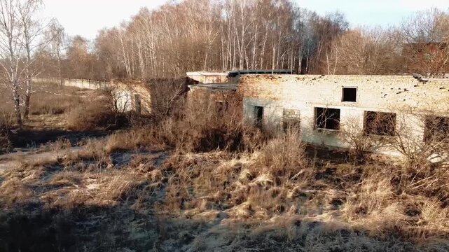 An old, abandoned building set against the backdrop of autumn nature.