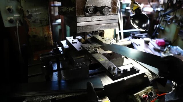 Press machine stamping a tooth pattern into a long flat steel saw blade