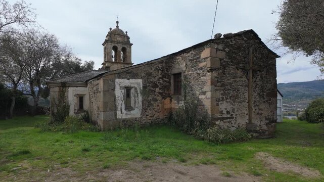Exterior view of the historic Santa Mar&iacute;a de Mones Church in Pet&iacute;n, Ourense, Galicia, Spain, showing its traditional stone construction and peaceful rural surroundings.