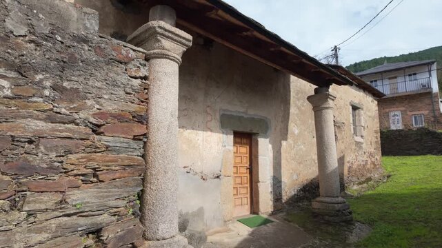 Side exterior view of the historic San Miguel de Mones Church in Pet&iacute;n, Galicia, Spain, showing traditional stone walls and simple rural construction