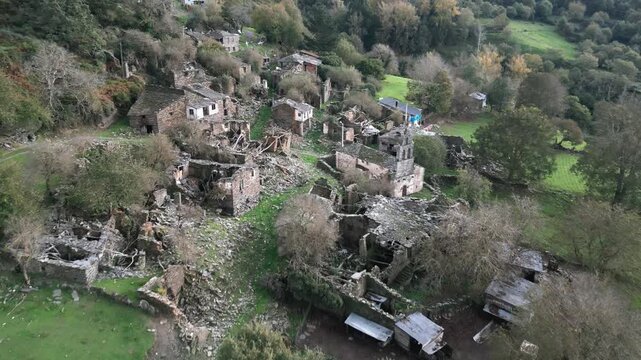 Aerial view over Santoalla do Monte in Galicia, Spain, showing the small rural settlement, stone houses, green fields and surrounding mountain landscape