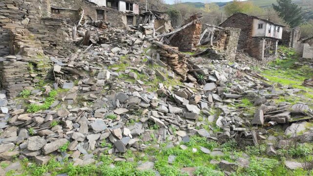 Collapsed stone houses and abandoned ruins in Santoalla do Monte, Galicia, Spain, showing the visible effects of rural depopulation and long-term decay.