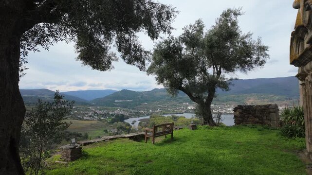 Peaceful rural landscape surrounding Santa Mar&iacute;a de Mones in Pet&iacute;n, Galicia, Spain, with mature trees, green meadows and distant hills framing the traditional countryside