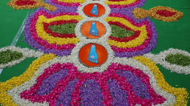 Slow motion of glittering blue footprint rangoli circles bordered by flowers at a South Indian Karnataka wedding ceremony during Saptapadi ritual.