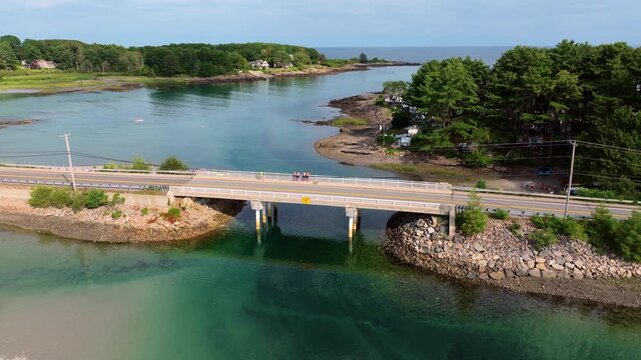 Aerial view of the Route 1A bridge crossing the Cape Neddick River in York, Maine, with paddleboarders, boats, and the shoreline of the historic Lobster Pound below.