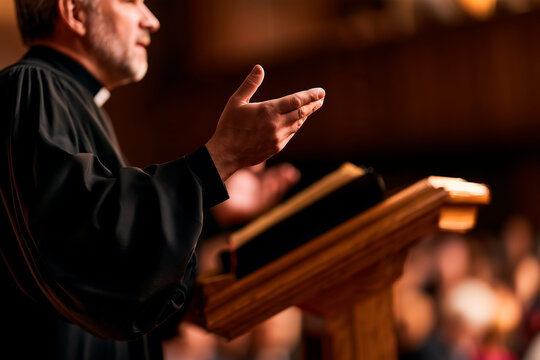Man priest standing at wooden pulpit giving sermon to church congregation. Speaker gesturing while preaching to audience in religious place. Faith, spirituality and community gathering