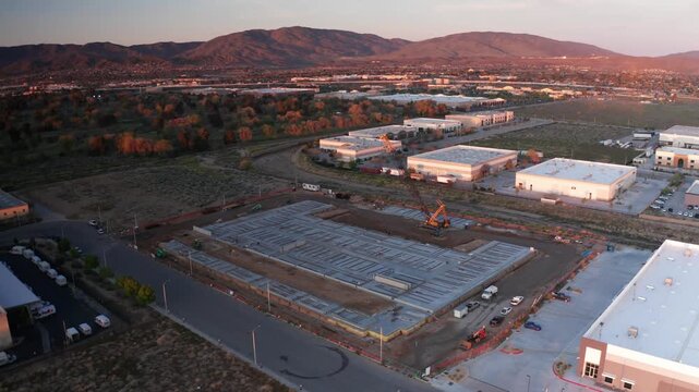 High aerial panning shot of a desert construction site at dawn in Palmdale, California. 4K