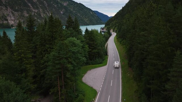 Vehicles Driving On A Lakeside Road Beside The Turquoise Water Of Lake Achensee In Tyrol, Austria. - aerial shot