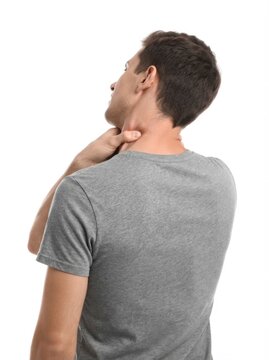 Young man suffering from neck pain on white background, back view