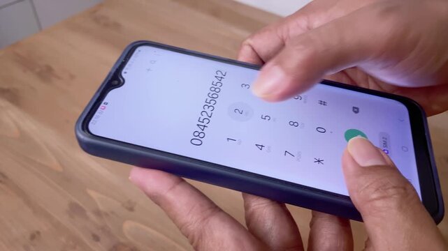 close up view of hand typing a phone number on a smart phone
