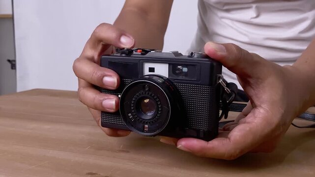 Hands advance film lever and presses shutter release button