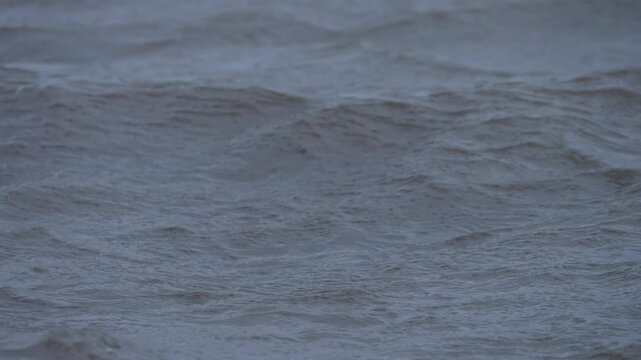 Wind shapes the lake surface into layered wave textures during cloudy weather