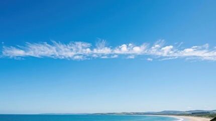 Fototapeta premium Thin band of soft white clouds across a vivid blue sky, minimalist atmospheric photography, bright clean daylight, airy horizontal composition, abundant copy space, optimistic travel and environmental