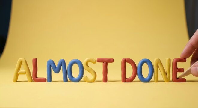 Almost Done Clay Lettering with Hand Placing Final Letter on Yellow
