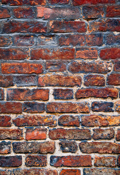 Close-up of a weathered historic brick wall on Steep Hill in Lincoln, Lincolnshire, showing irregular handmade bricks, aged mortar and rich red-brown textures.