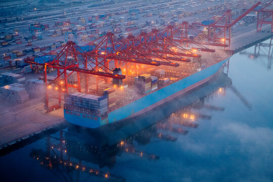 Container ship loaded with containers at port terminal in a beach