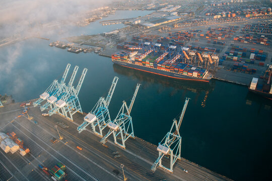 Container ship docked at port with cargo containers and cranes