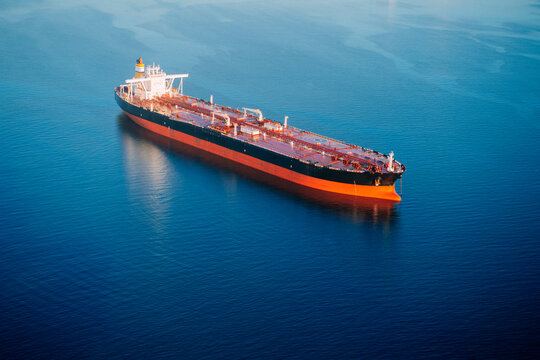 Oil tanker ship anchored in calm ocean in a beach