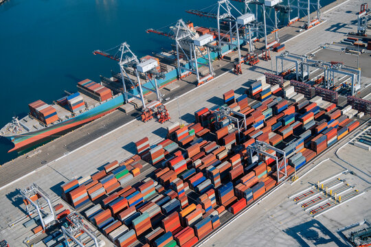 Container port with cargo ship and cranes in a beach