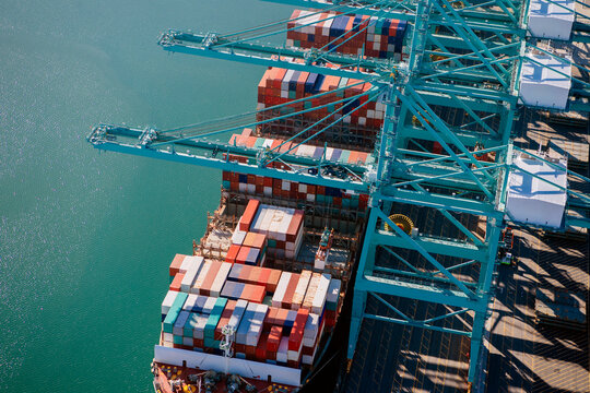 Container ship loading at port cranes in long beach, california