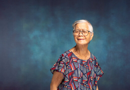 Smiling senior woman portrait against blue textured background