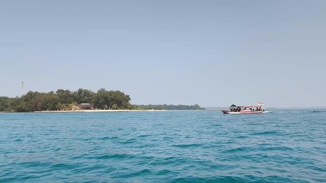 Passenger boat passing near wooded island coast in sea