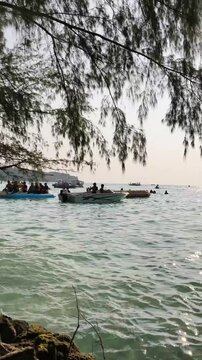 Jakarta, Indonesia - April 24, 2026: Tourists riding motorboat near clear water beach shore