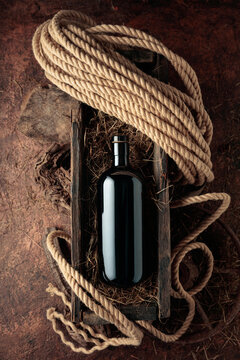 Dark glass bottle of hard liquor in a vintage wooden box.