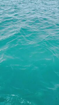 Texture of clear turquoise sea water surface reflecting sunlight