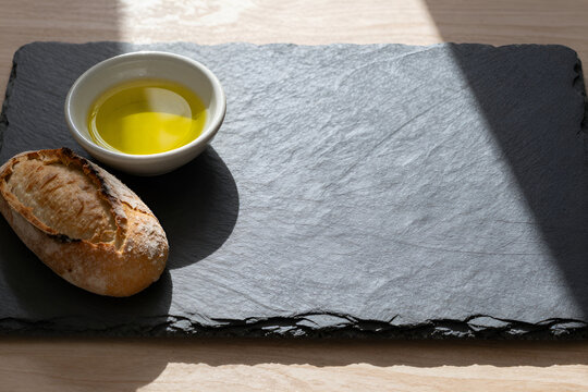 Olive oil and bread on slate board