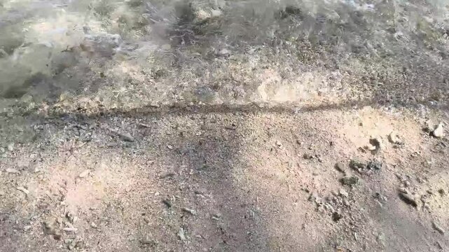 Wet beach sand texture lines left by sea water wave movement