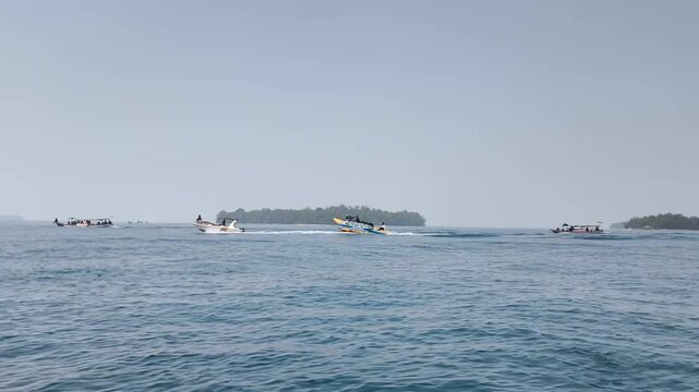 Fishing boat sailing in the middle of blue ocean between islands