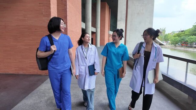 Medical students in scrubs walk together through a university campus, talking and carrying study materials, showing friendship, peer interaction, medical education, and student lifestyle.