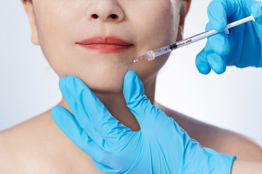 Cosmetologist Giving Lip Filler Injection to Woman